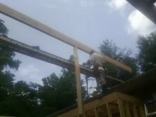 Carpenter setting a ridge beam over a new addition frame — Ice Dam Removal by Roofing Brothers in Derwood