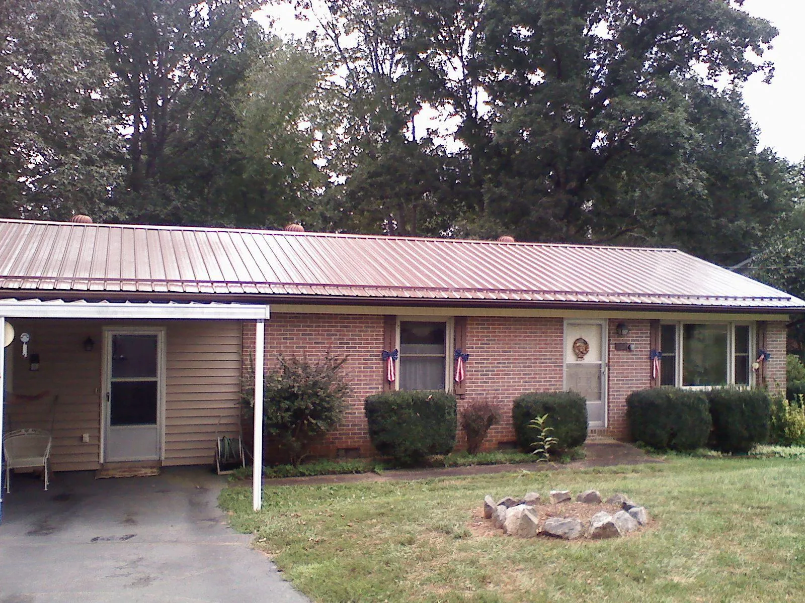 Bronze metal roof and carport on a brick ranch home — Roof Repair work by our crew in Derwood