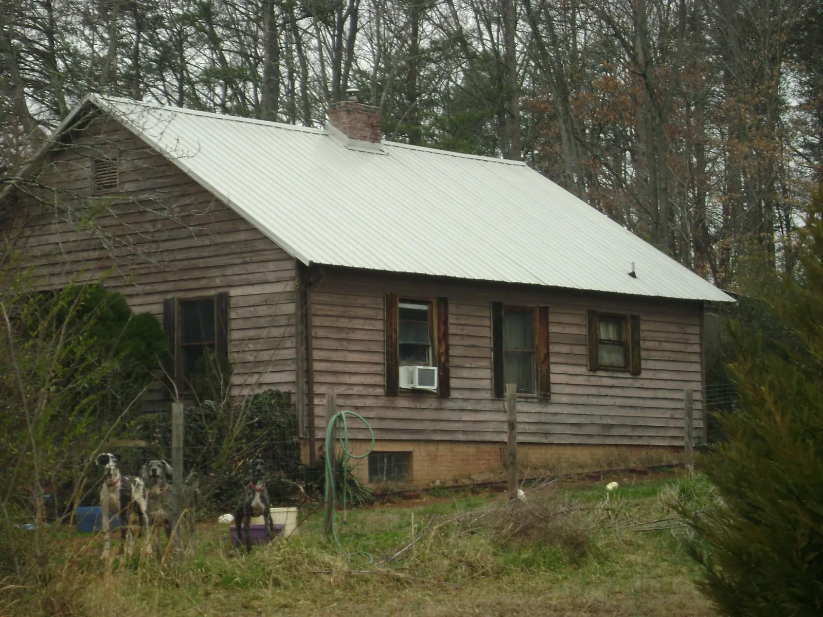 White metal roof on an old wood sided farmhouse, from a Metal Roof Installation job in Derwood
